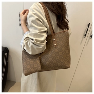 Detail of vintage patterned tote bag with small matching pouch and gold rivet accents