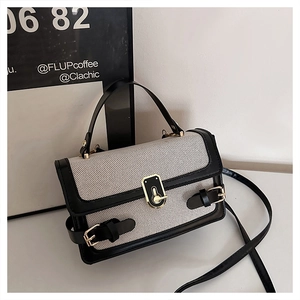 Detail of vintage color-block handbag with gray canvas texture and black leather trim