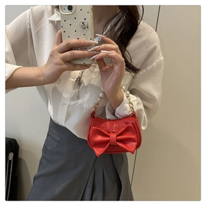 Detailed shot of red mini bag with large bow and pearl handle chain