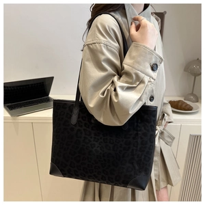 Close-up of black leopard print suede tote bag with leather corner reinforcement