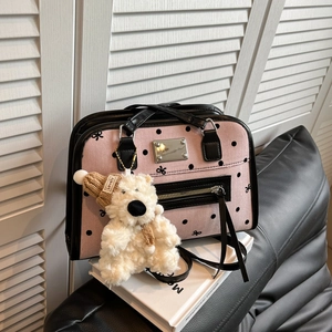 Sac fourre-tout rose à pois avec garniture noire et breloque ours en peluche sur livres