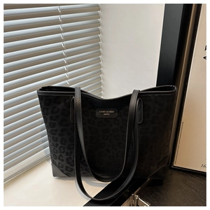 Detail of black leopard print suede tote bag with slim straps and fashion logo patch