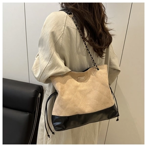 Detail of quilted suede tote bag with golden chain strap and mixed material textures
