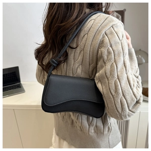 Seitenansicht der schwarzen Schultertasche aus Leder mit Knotendetail am Riemen