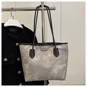 Silver tote bag with rock texture, golden metal bar and long black shoulder straps