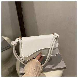 Detail der weißen Satteltasche mit asymmetrischer Klappe und dickem Knotenschultergurt