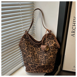 Close-up of leopard print tote bag with brown leather straps in a sunlit interior