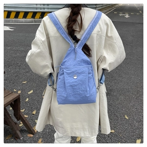 Detail of light blue wrinkled nylon backpack with M logo and silver metal hardware