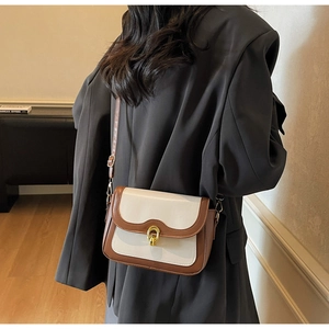 Detail view of contrast vintage crossbody bag with gold twist lock and matte leather texture