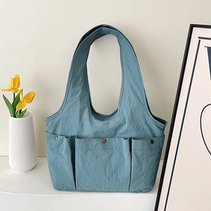 Morandi blue pleated tote bag with three front pockets and metal rivet details