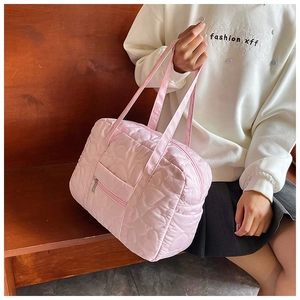 Detailed pink heart-quilted travel tote bag with double handles and front zipper pocket