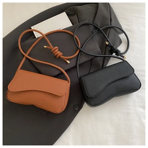 Detailansicht minimalistischer Ledertaschen mit Rundboden und Knotengurt in Braun und Schwarz