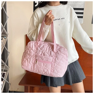 Detailed view of pink quilted heart tote bag with front zipper pocket and long handles