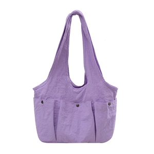 Light purple pleated nylon tote bag with three front snap pockets and wide shoulder straps