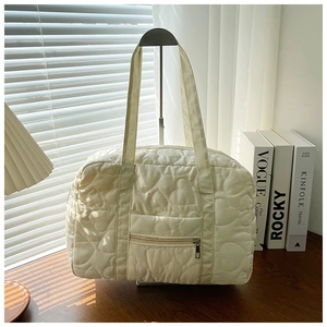 Close-up of cream white quilted heart pattern on lightweight large capacity shoulder bag