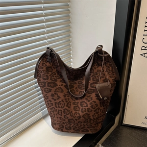 Chic leopard print oversized tote bag with leather handles shown in a modern interior