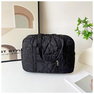Detail of black quilted diaper bag with heart patterns and functional zipper pocket