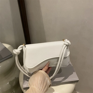 Minimalistische weiße Umhängetasche mit gedrehtem Seilgriff und Goldakzenten
