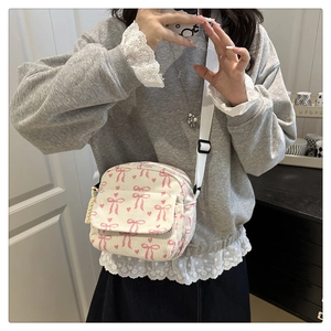 Détail du sac bandoulière en velours côtelé avec motifs nœuds et sangle réglable