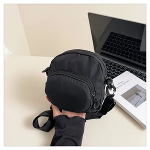 Close-up of black nylon canvas crossbody bag with dual zipper compartments for daily use