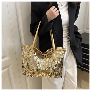 Détail du sac cabas à paillettes dorées porté épaule avec finition métallique brillante