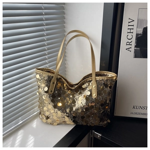 Gros plan d'un sac cabas à paillettes dorées avec texture métallique et rivets