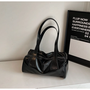 Detail of black glossy patent leather shoulder bag with smooth zipper and vintage texture