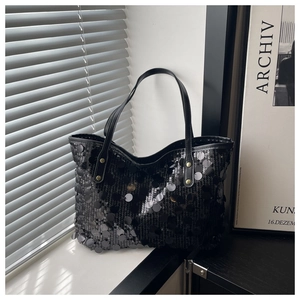 Détail du sac cabas à paillettes noires avec anses en cuir et rivets dorés brillants