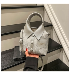 Detail of shirt-style handbag in silver leather featuring collar and button accents