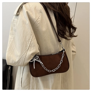 Detail of dark brown suede shoulder bag with silver chain and star charm decoration