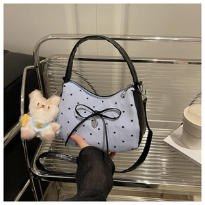 Détail du sac hobo à rayures bleues, motifs cœurs et breloque en peluche pour femme