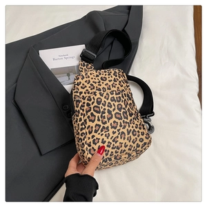 Close-up of leopard print crossbody bag with black adjustable strap on casual wear