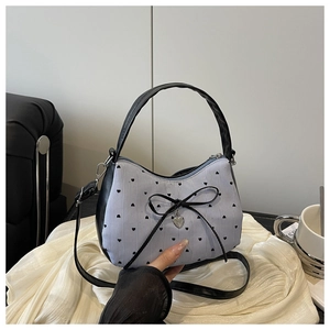 Détail du sac à rayures bleues avec imprimés cœurs et pendentif cœur en argent