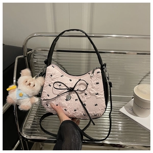 Vue détaillée du sac à main rose et noir avec nœud en soie et breloque chiot en peluche