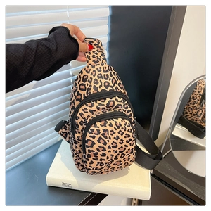 Détail du sac bandoulière léopard avec poches zippées multicouches et sangle en nylon