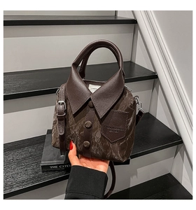 Detail of creative shirt-shaped bucket bag in dark brown leather with collar and buttons