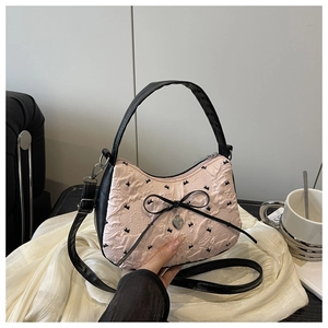 Détail du sac à main en tissu rose avec broderies nœuds noirs et pendentif en cœur