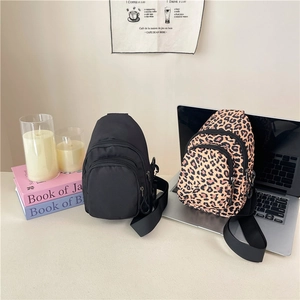 Sacs bandoulière en nylon léopard et noir avec sangle réglable présentés sur un bureau
