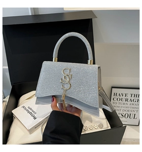 Dettaglio della borsa a trapezio argento glitterata con logo a S e finiture in metallo