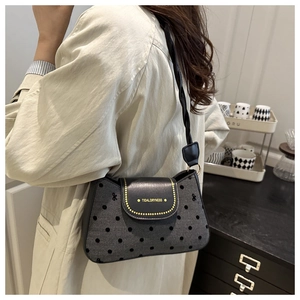 Détail du sac sous le bras rétro à pois avec rabat élégant en cuir noir de haute qualité