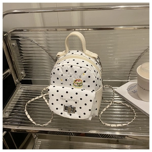 Detailed view of polka dot mini backpack with burger embroidery and metal turn-lock closure