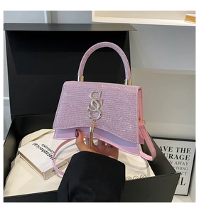 Dettaglio della borsa con paillettes rosa con nappa dorata e logo in metallo