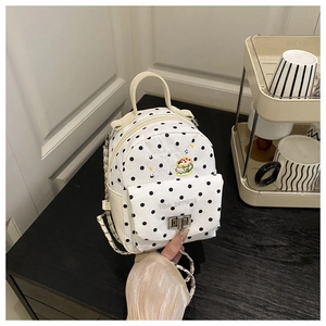Detailed view of mini polka dot backpack with chain strap and metallic twist-lock