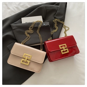 Detail of glossy patent leather crossbody bags with golden chain straps and square buckles