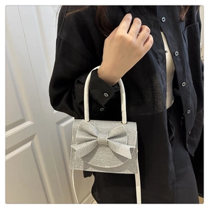 Close-up of silver sequin handbag featuring a structured bow and sparkling texture