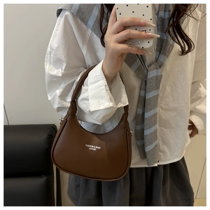Close-up of brown leather crescent bag with short handle and logo print