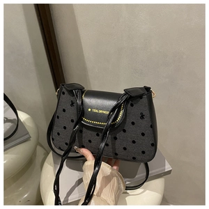 Détail du sac à bandoulière à pois avec texte Tidal Dryness et finitions dorées