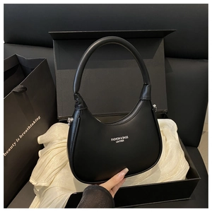 Glossy black crescent bag with silver zipper detail and premium gift packaging