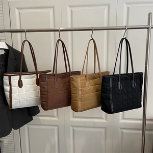 Quilted check tote bags in white, brown, khaki, and black colors on a metal hanger