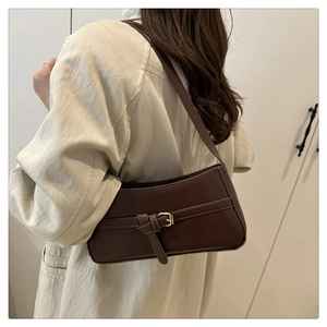Detail view of dark coffee faux leather baguette bag with vintage gold buckle strap